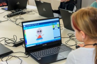 Kind am Laptop mit geöffnetem Mal-Programm Paint
