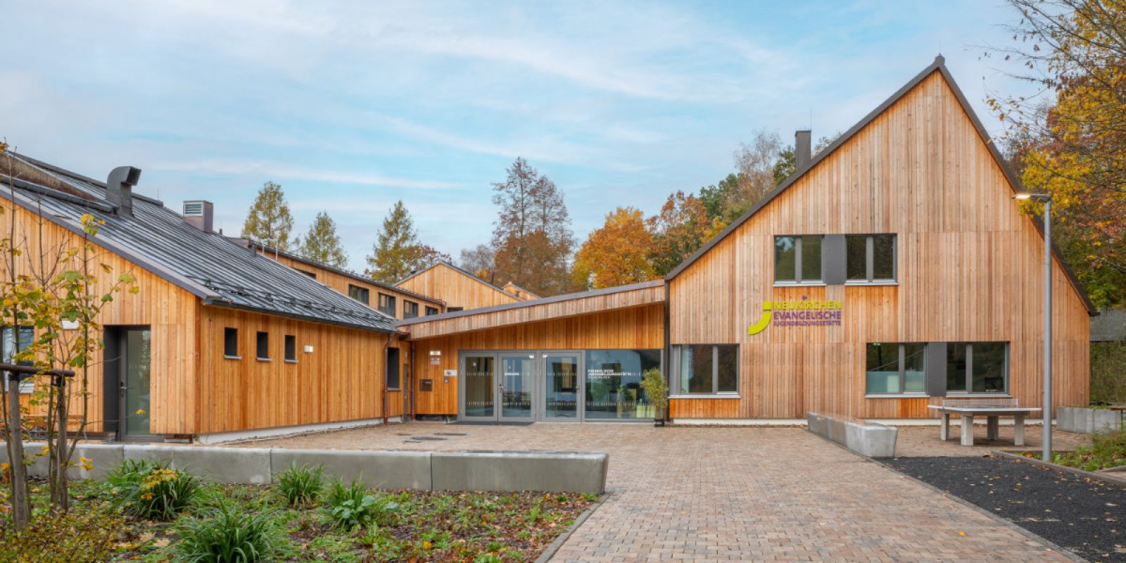 Frontale Außenansicht Gebäude Jugendbildungsstätte Neukirchen mit Holzfassade