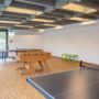 Großer Raum mit Tischtennisplatten und Kickertisch
